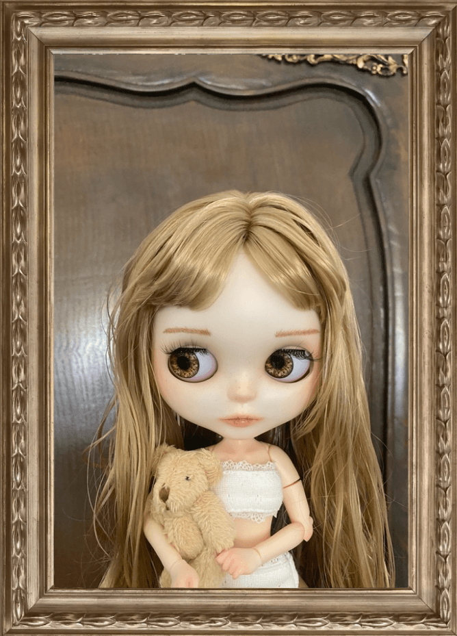 A pale gothic Blythe doll resting in a silk-lined coffin box